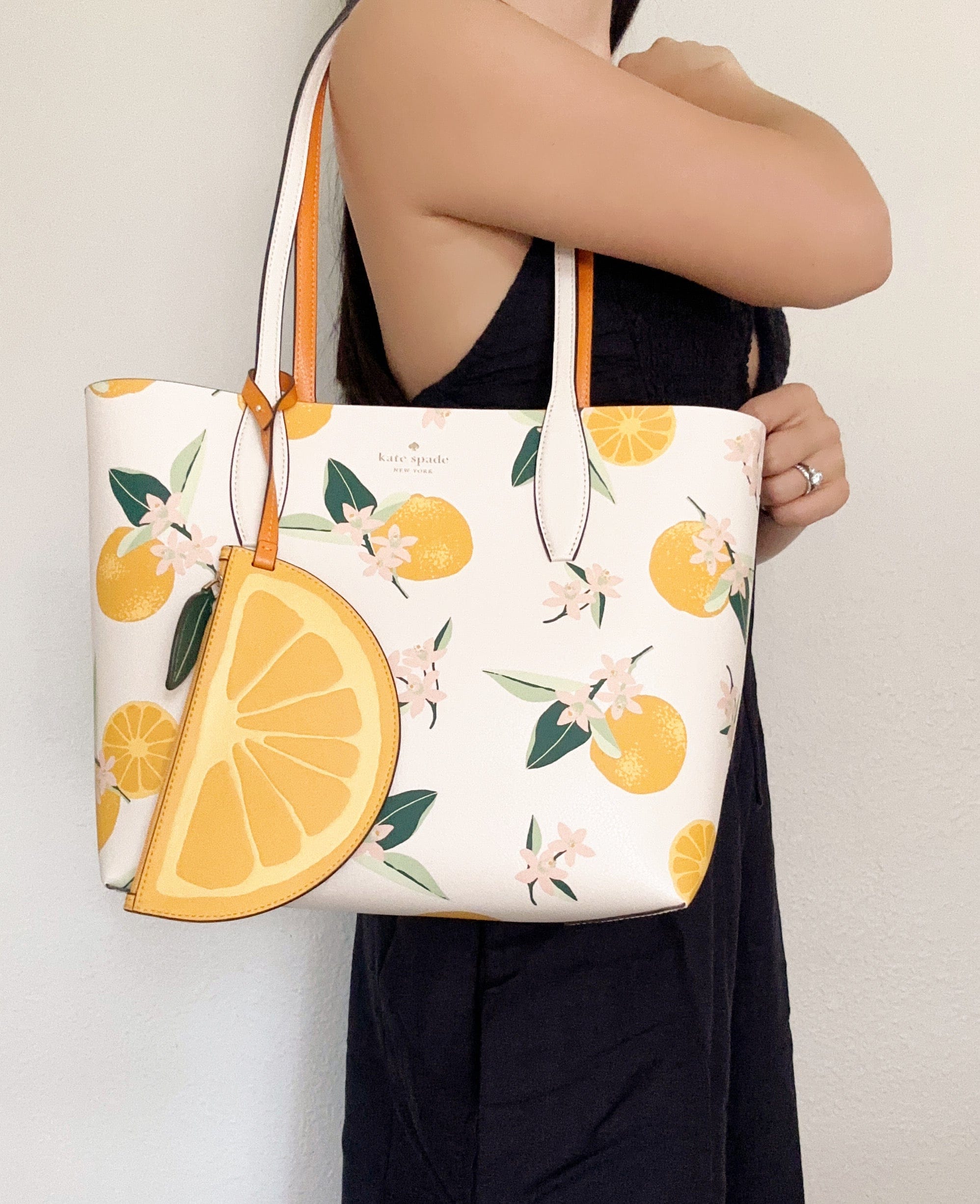 https://gabysbags.com/cdn/shop/files/kate-spade-clementine-small-reversible-tote-cream-multi-orange-zip-pouch-clutch-57532202680548_1996x.jpg?v=1693127677